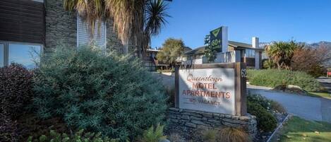 A sign for Queenscrown Motel Apartments with a clear indication of no vacancies.