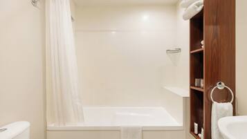 A bathroom with a bathtub, a toilet, and a sink.