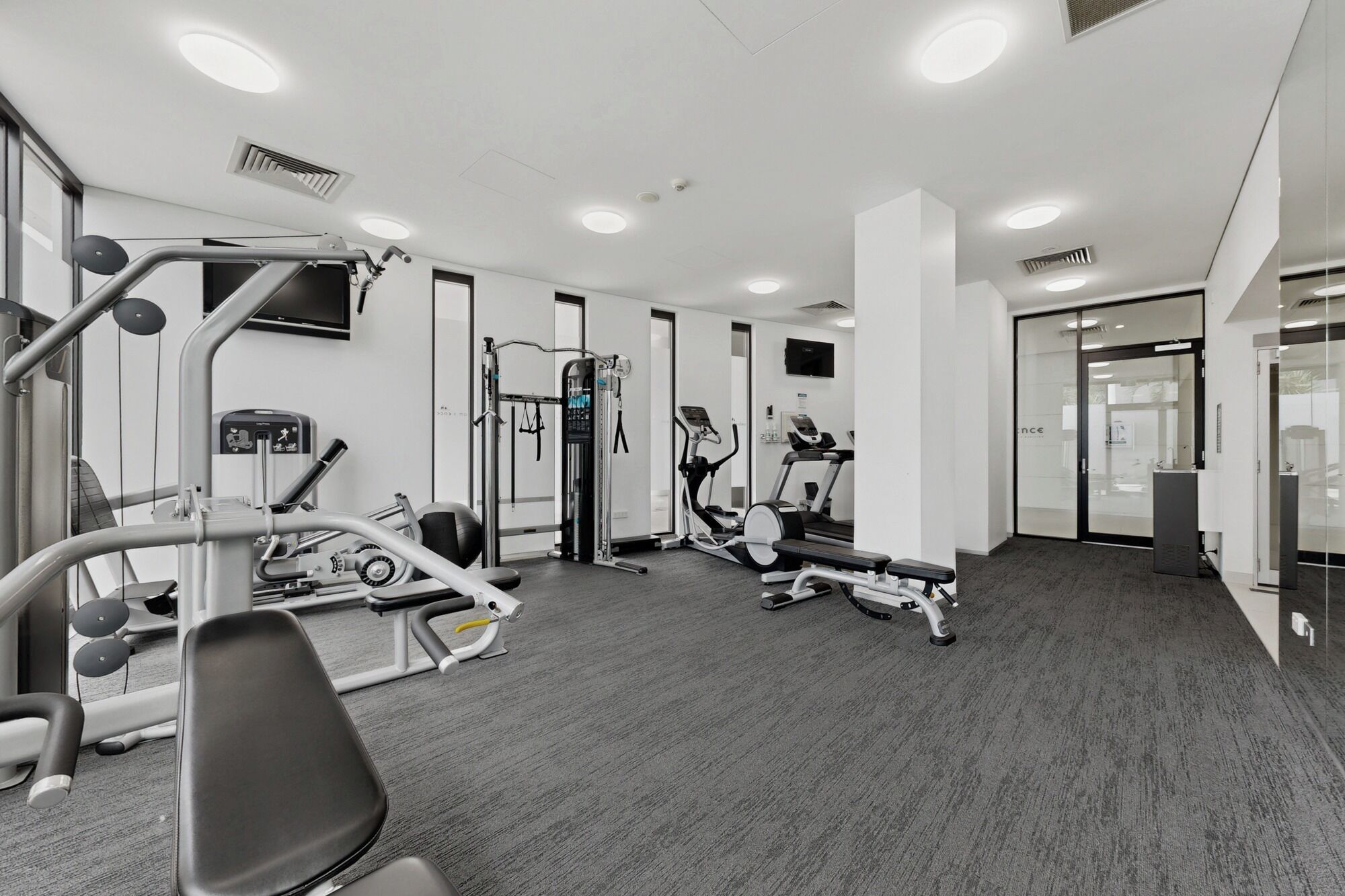A modern gym with various exercise equipment, including treadmills and weight machines.
