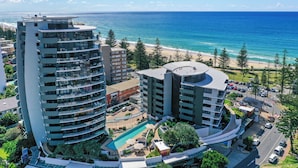 A high-rise hotel with multiple balconies overlooking a beach and ocean. - Ambience on Burleigh Beach (Burleigh Heads)
