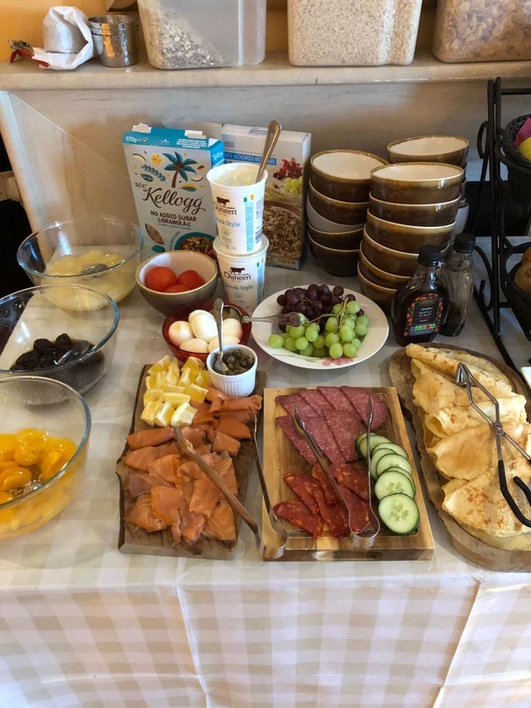 A buffet table with various food items and condiments.