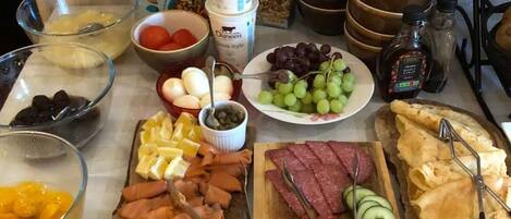 A buffet table with various food items and condiments.