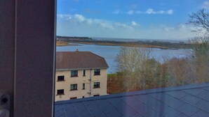 A view of a river with buildings in the foreground and a clear sky. - St Judes Lodge (Galway)