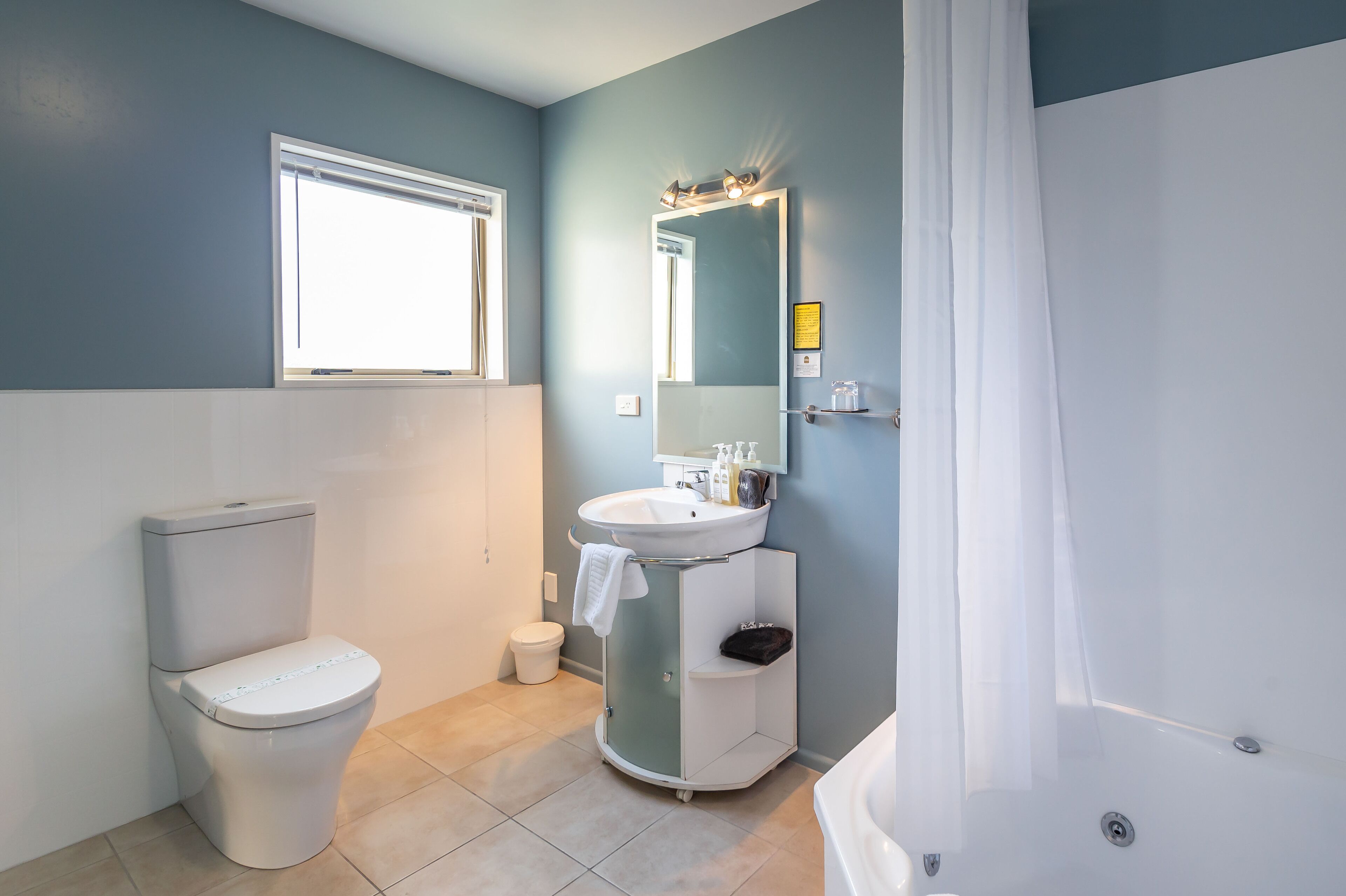 Un baño con inodoro, lavabo y ducha.