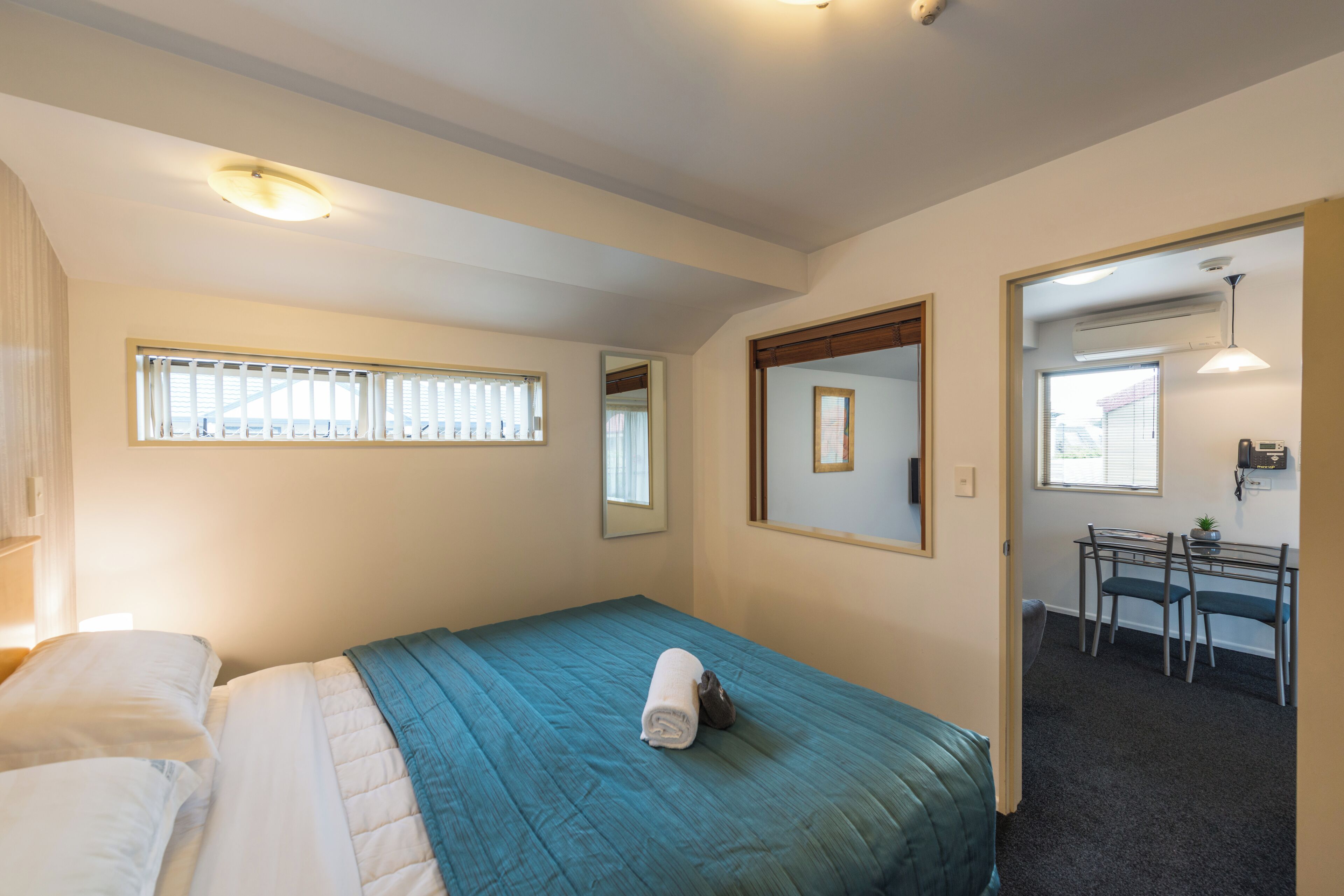 A bedroom with a bed, a desk, and a chair.