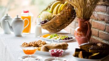 Una colazione con una varietà di cibi, tra cui frutta, dolci e bevande.