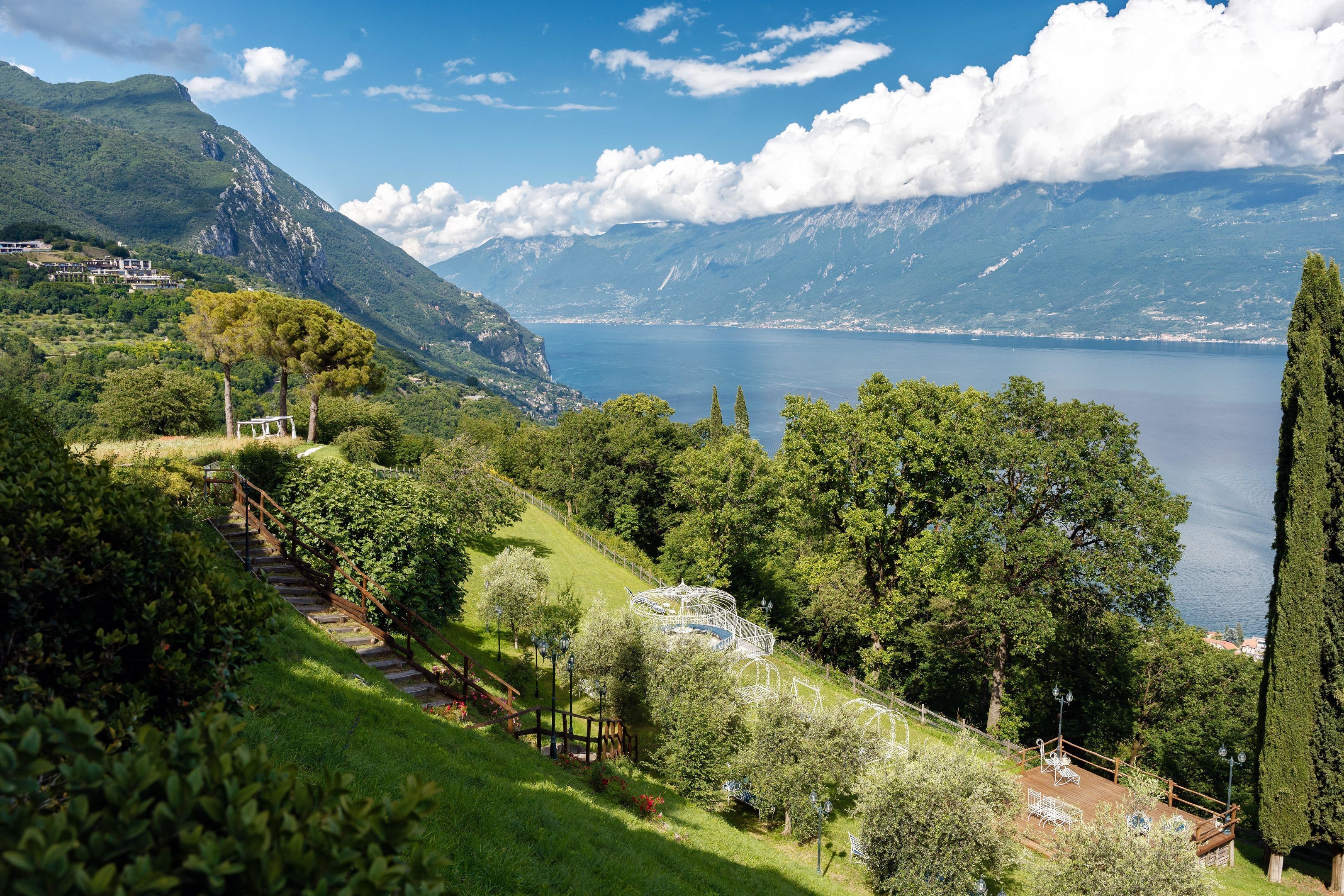 A mountainous landscape with a lake, a wooden staircase, and a gazebo.