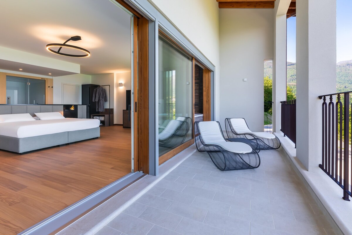 Una sala de estar moderna con un sofá y un balcón con sillones de relax.