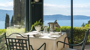 A table set for dining with a view of a lake and mountains.