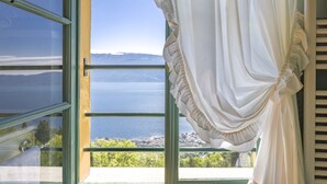 A window with a view of a body of water and a distant landscape.