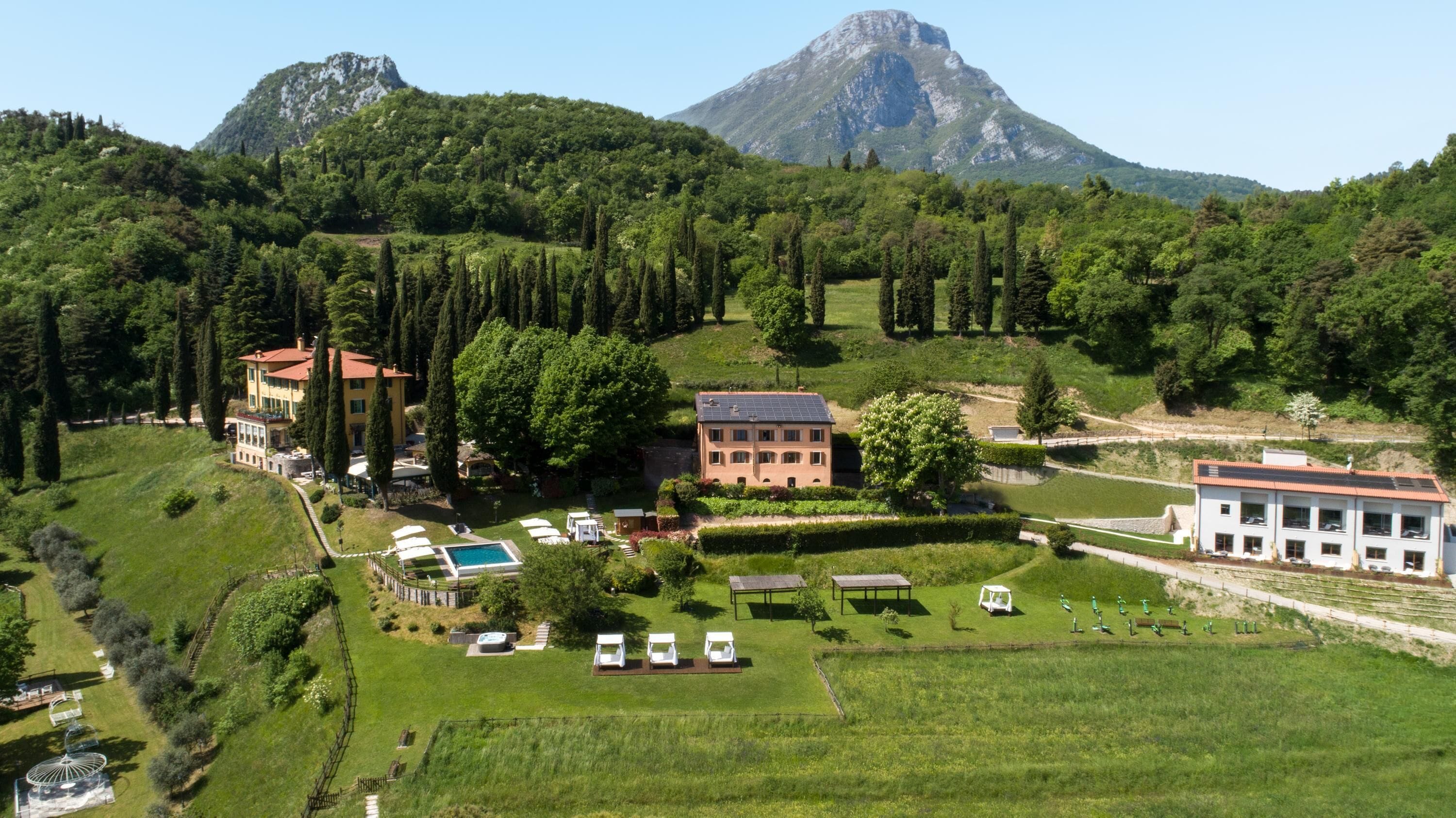 Ein Resort mit mehreren Gebäuden, einem Schwimmbad und einer Bergkulisse.