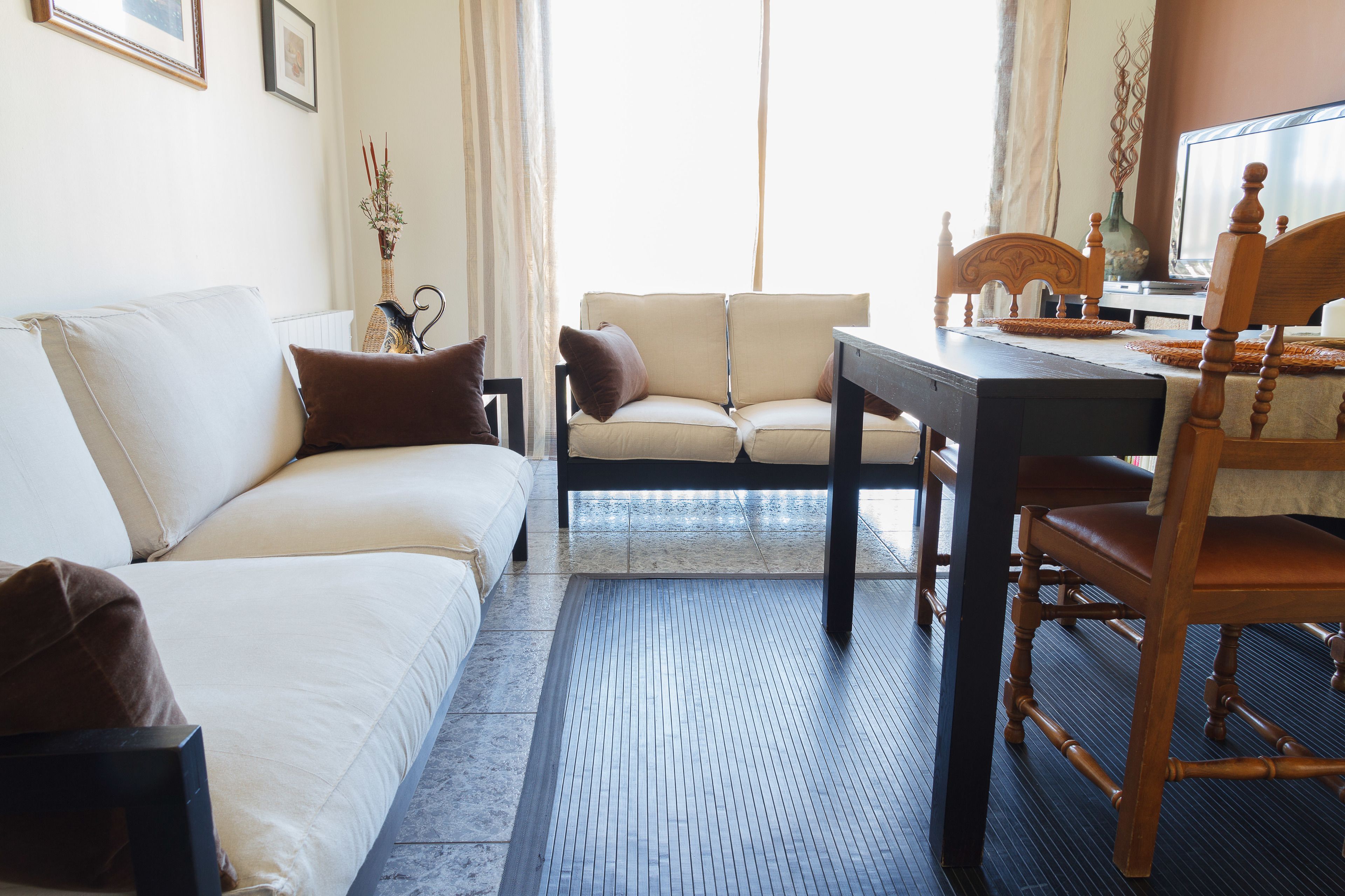 A hotel room with a sofa, a dining table, and a chair.
