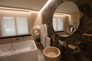 A modern bathroom with a bathtub, a large mirror, and a sink.
