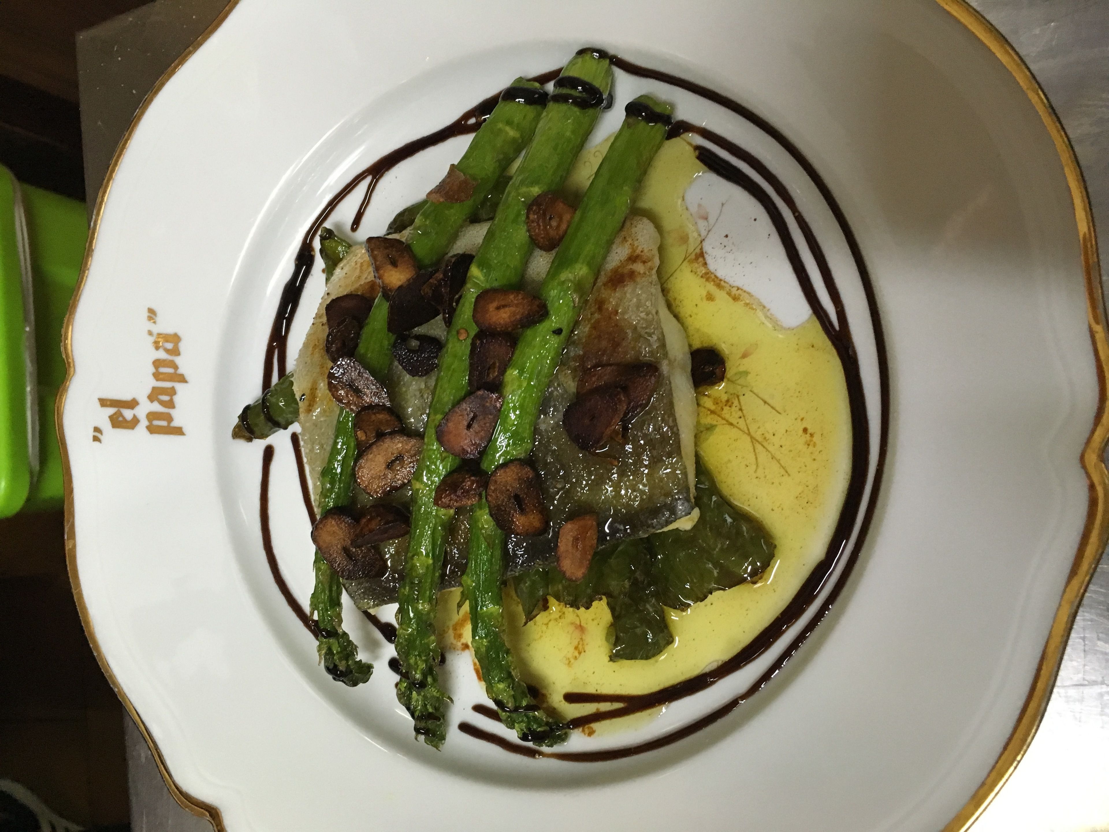 A plate of food with asparagus, mushrooms, and a sauce.