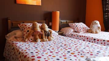 Two beds with polka dot bedspreads, a wooden headboard, and a unique lamp sit in this inviting space.