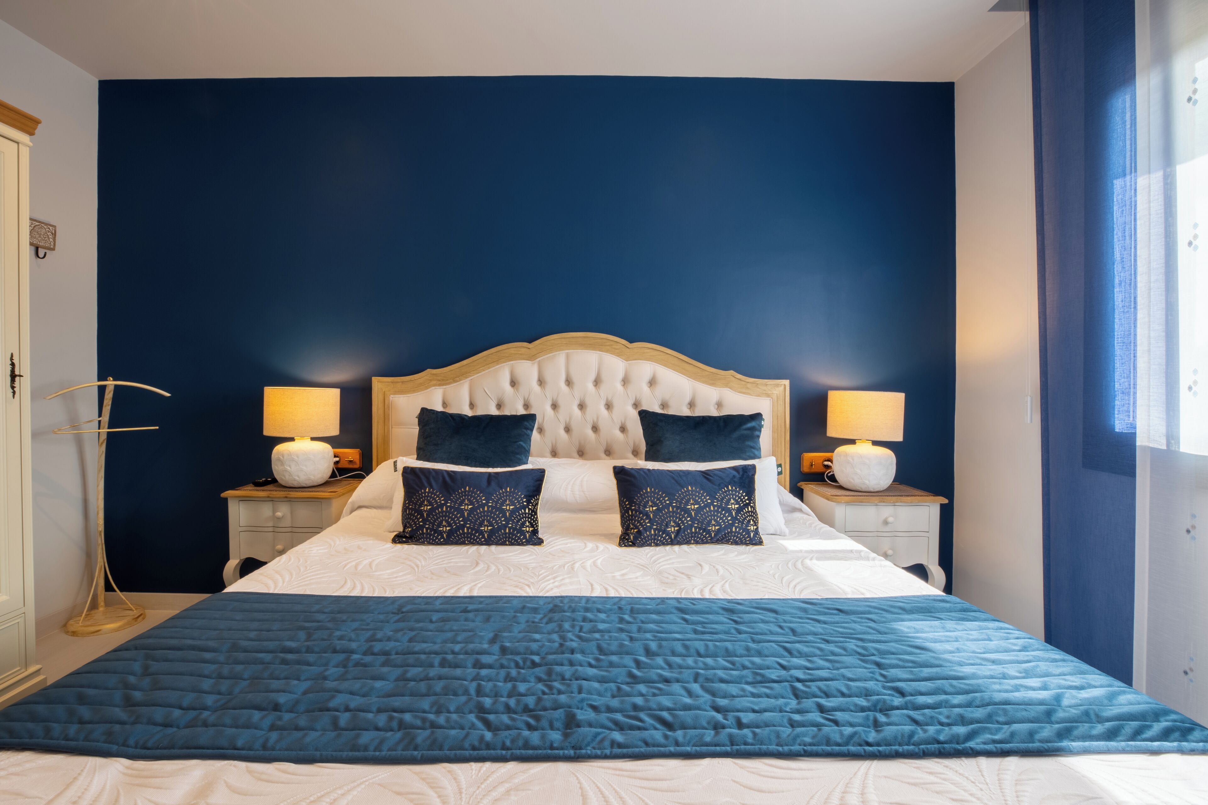 Une chambre à coucher avec un grand lit, deux tables de chevet et une commode.