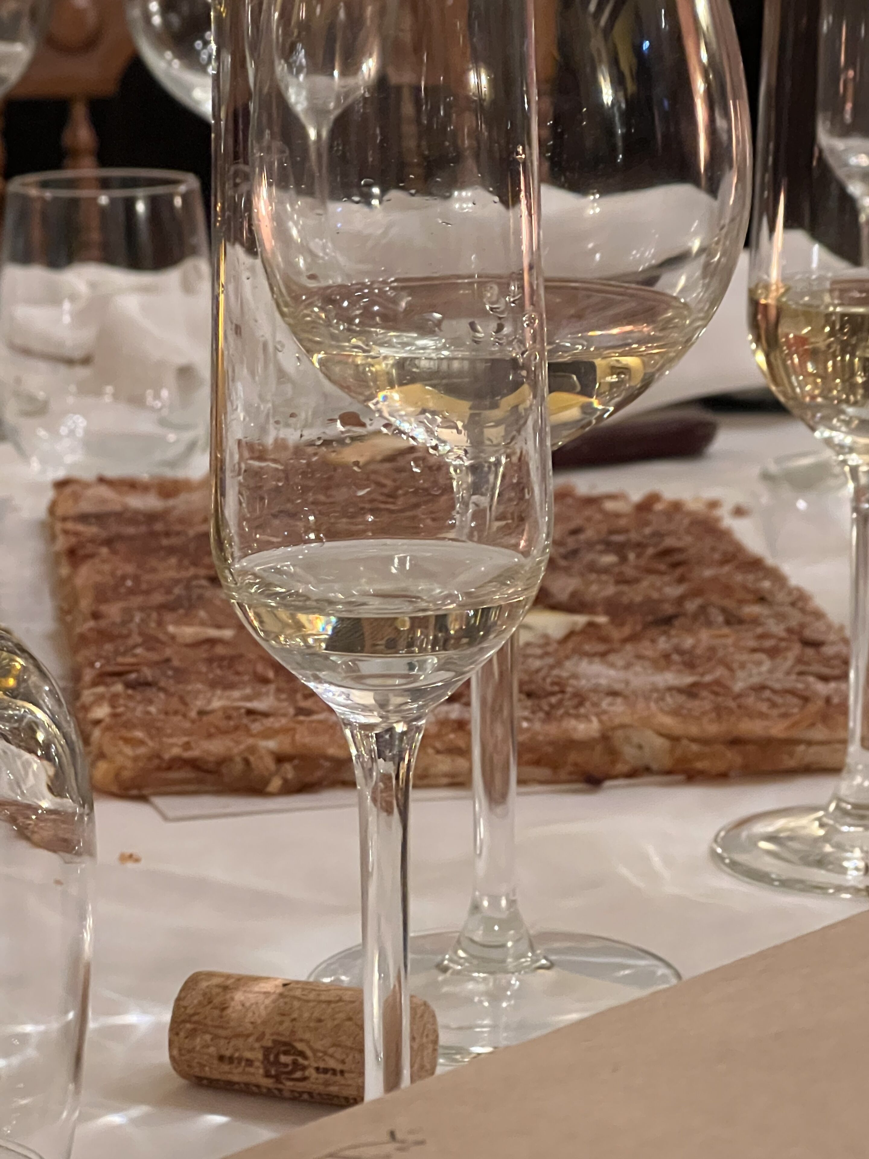 A table with several empty wine glasses and a cork.