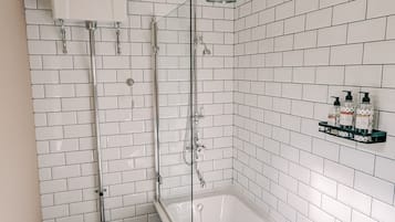 Un baño con una bañera blanca, un inodoro y una ducha.