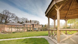 A traditional stone building with a wooden pavilion in a landscaped garden. - Oakhill  (Matlock)