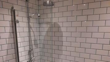 A bathroom with a freestanding bathtub, a glass-enclosed shower, and a tiled floor with a star pattern.