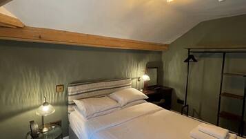 Een slaapkamer met een groot bed, twee bedlampen, een nachtkastje en een kledingkast.
