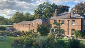 A large brick house with a well-maintained garden and a lawn. - Oakhill  (Matlock)