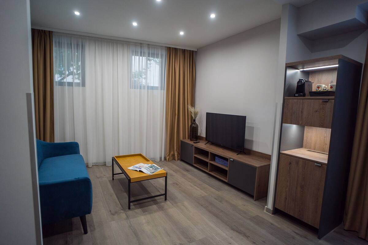 A modern living room with a sofa, a coffee table, a TV, and a wooden cabinet.