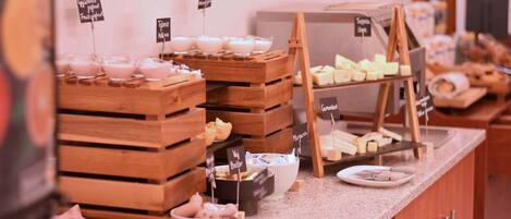 A buffet with various food items including yogurt, cheese, and bread.