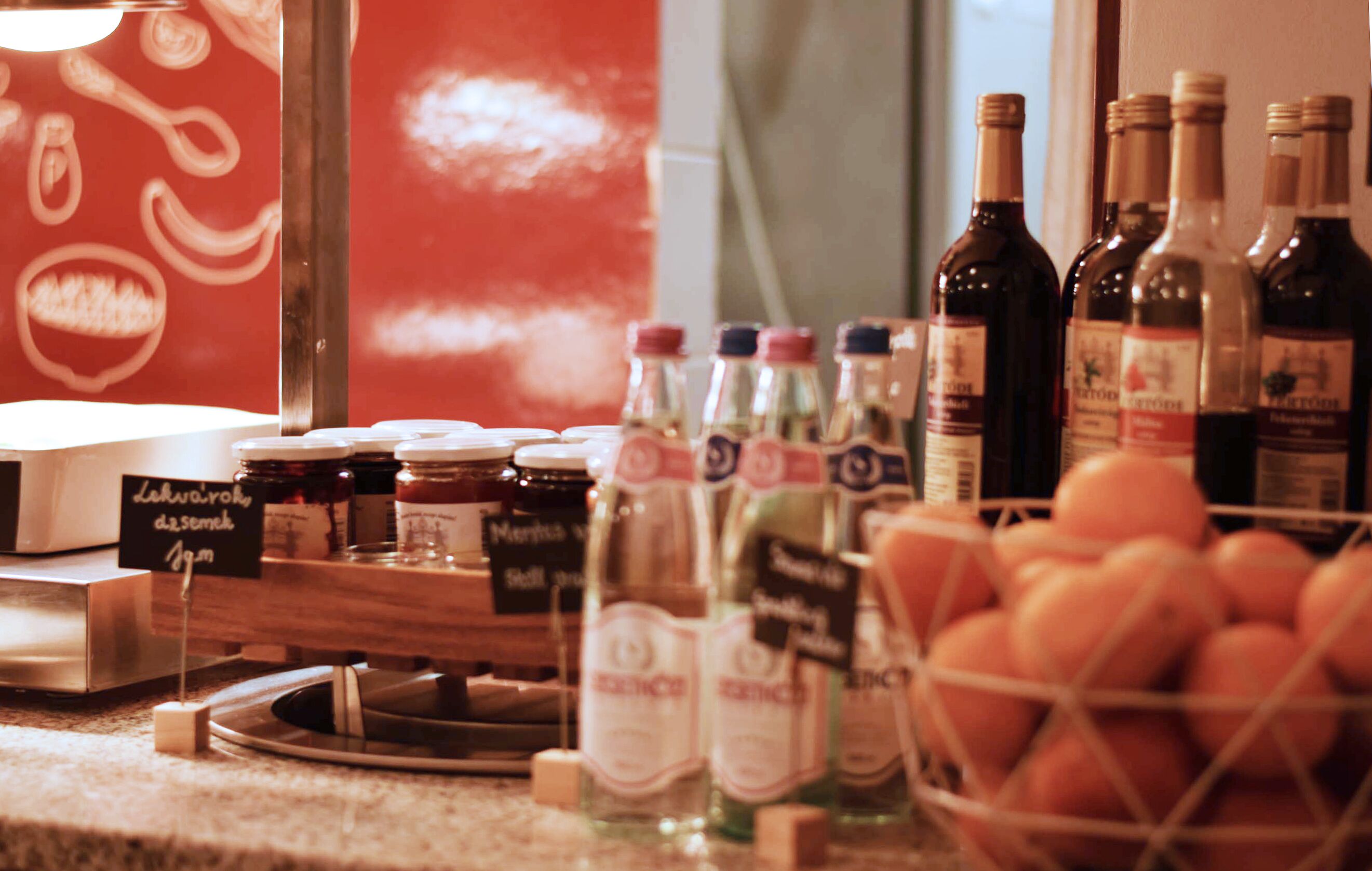A variety of bottles and jars on a counter, with a sign indicating a dessert option.