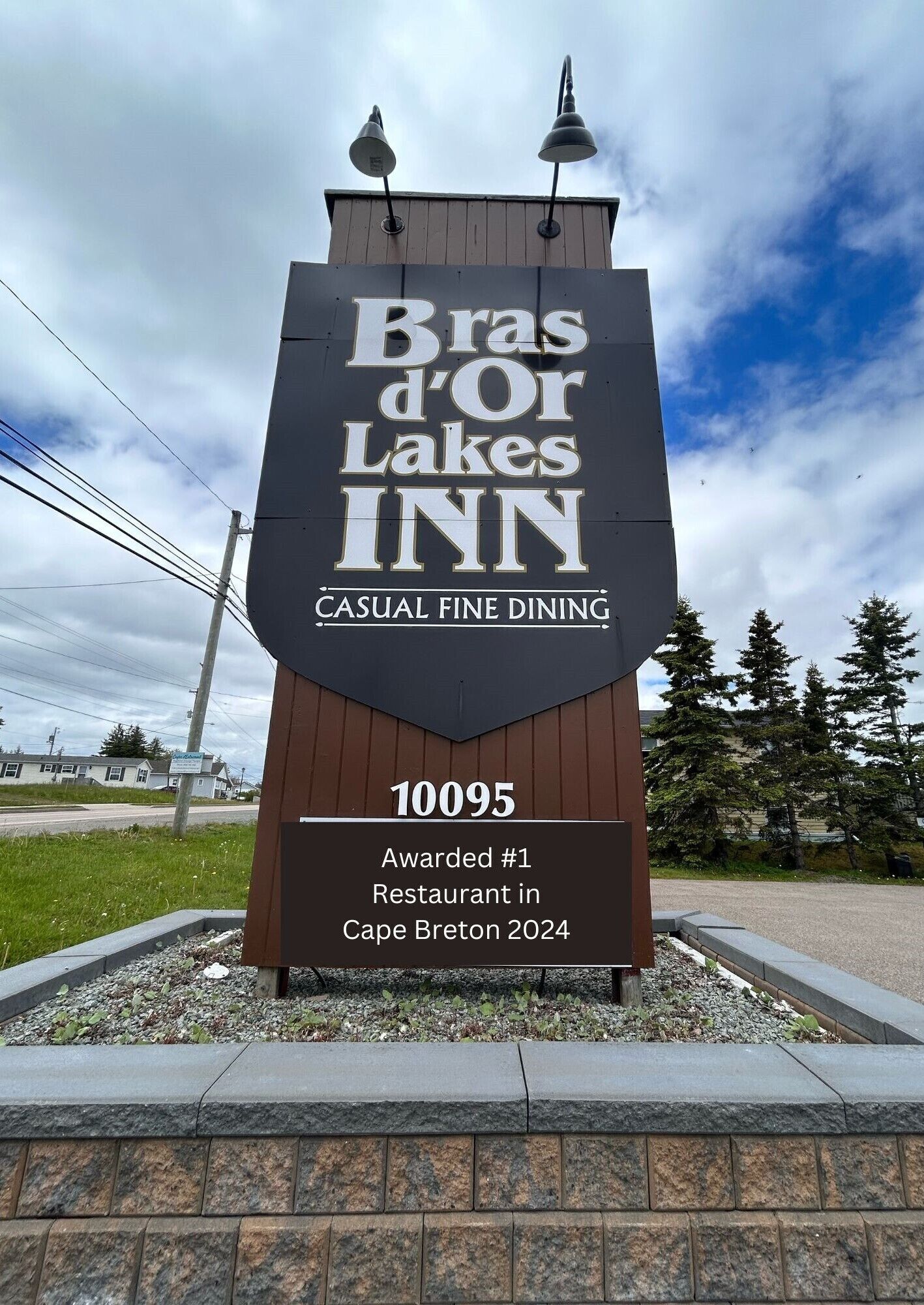 Placa do Bras d'Or Lakes Inn, indicando que é um restaurante de alta gastronomia com ambiente informal.