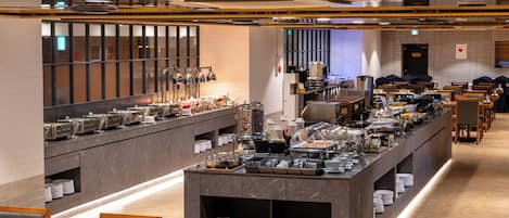 Un espace pour le petit-déjeuner, aménagé en buffet, avec plusieurs points de service, différents types de sièges et un décor intérieur moderne.