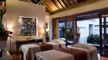 Two single beds with matching headboards, a desk, and a large window offering a view of the outdoors.