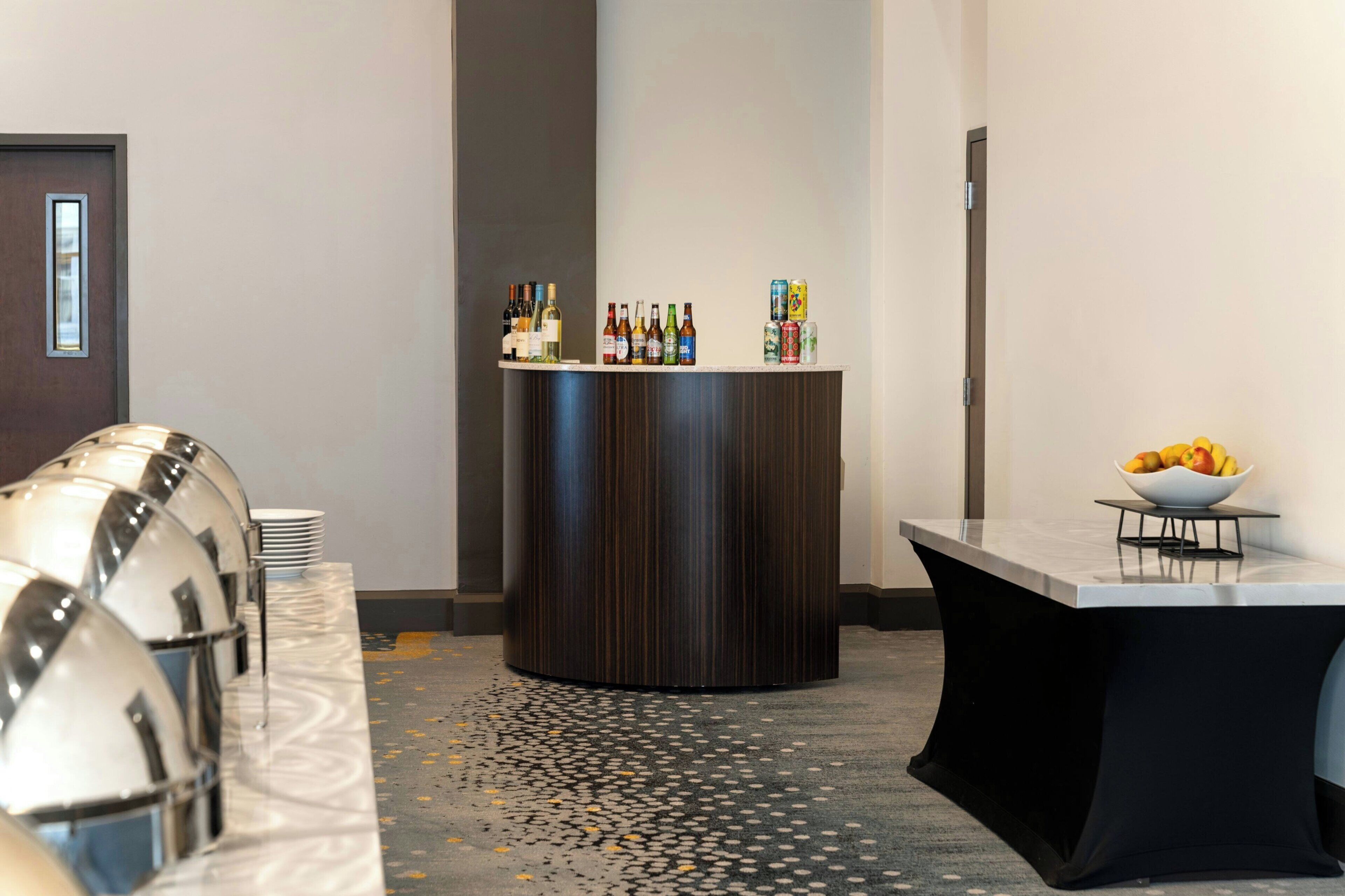 A hotel lobby with a reception desk, a seating area, and a decorative wall.