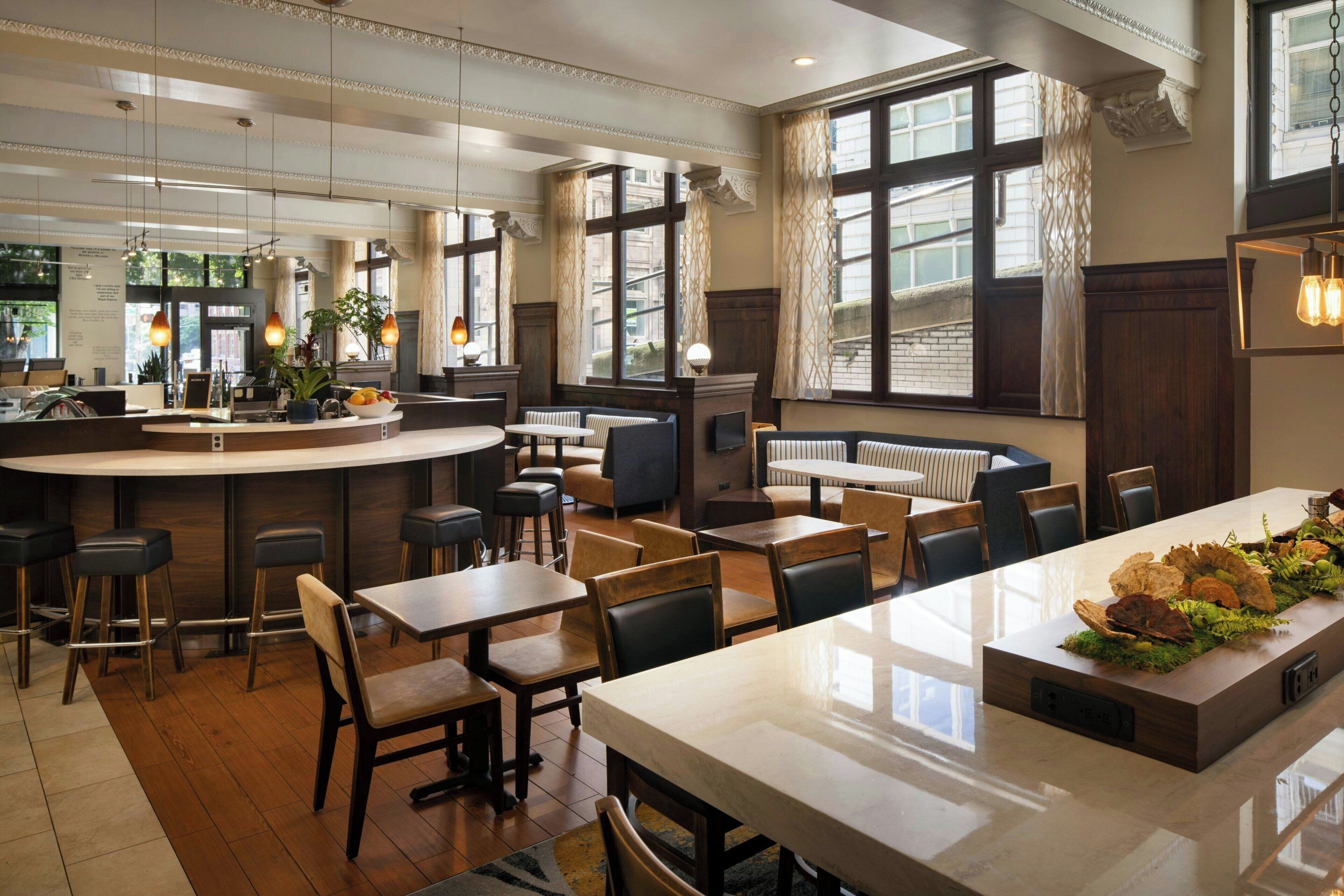 A modern restaurant interior with a bar area, seating arrangements, and large windows providing views.
