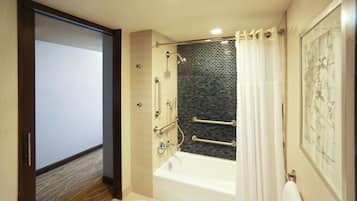 Ein modernes Badezimmer mit Badewanne, Dusche und Duschabtrennung aus Glas.