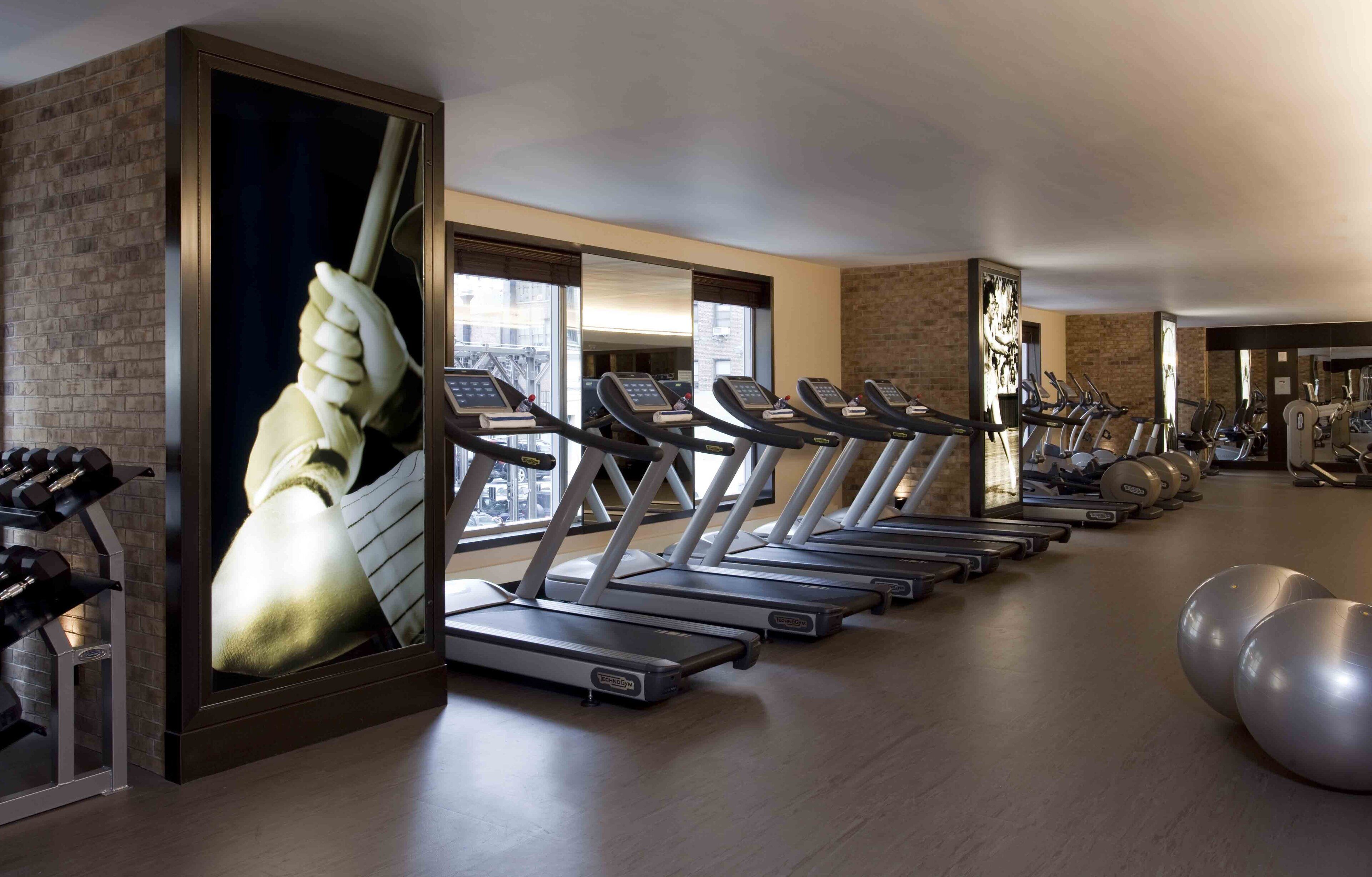 A gym with treadmills, exercise balls, and weights.