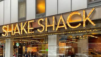 A restaurant named "SHAKE SHACK" with outdoor seating visible through the glass windows.