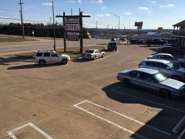 A parking lot with several cars parked, a motel sign, and a gas station in the background. - Rustic Motel Rolla (Rolla)
