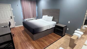 Habitación de hotel con cama, mesita de noche y una pequeña zona de estar con toallas.