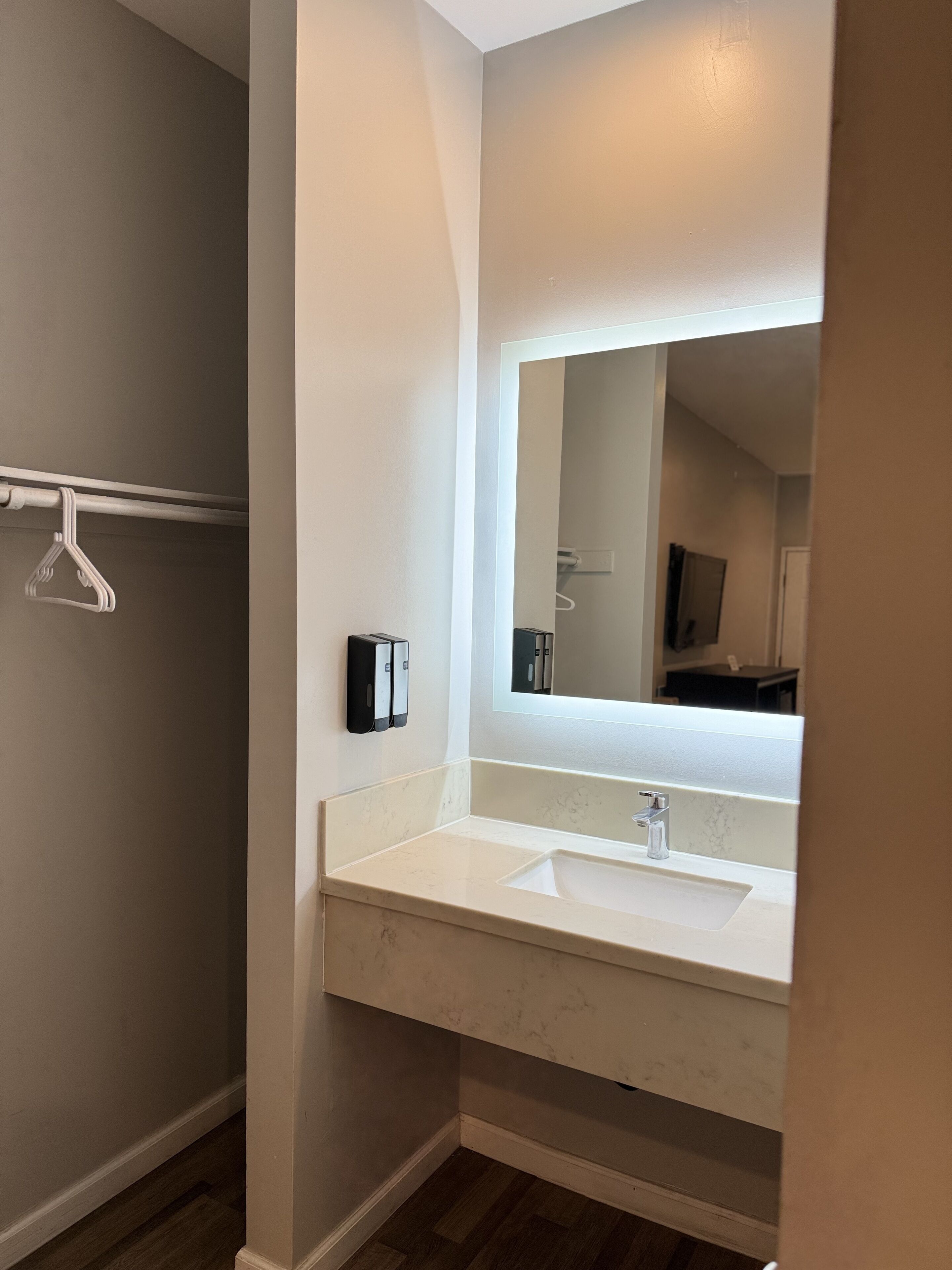 Une salle de bain avec un lavabo blanc, un miroir et un porte-serviettes.