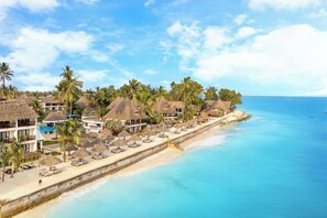 Privat strand, hvit sand, solsenger og parasoller