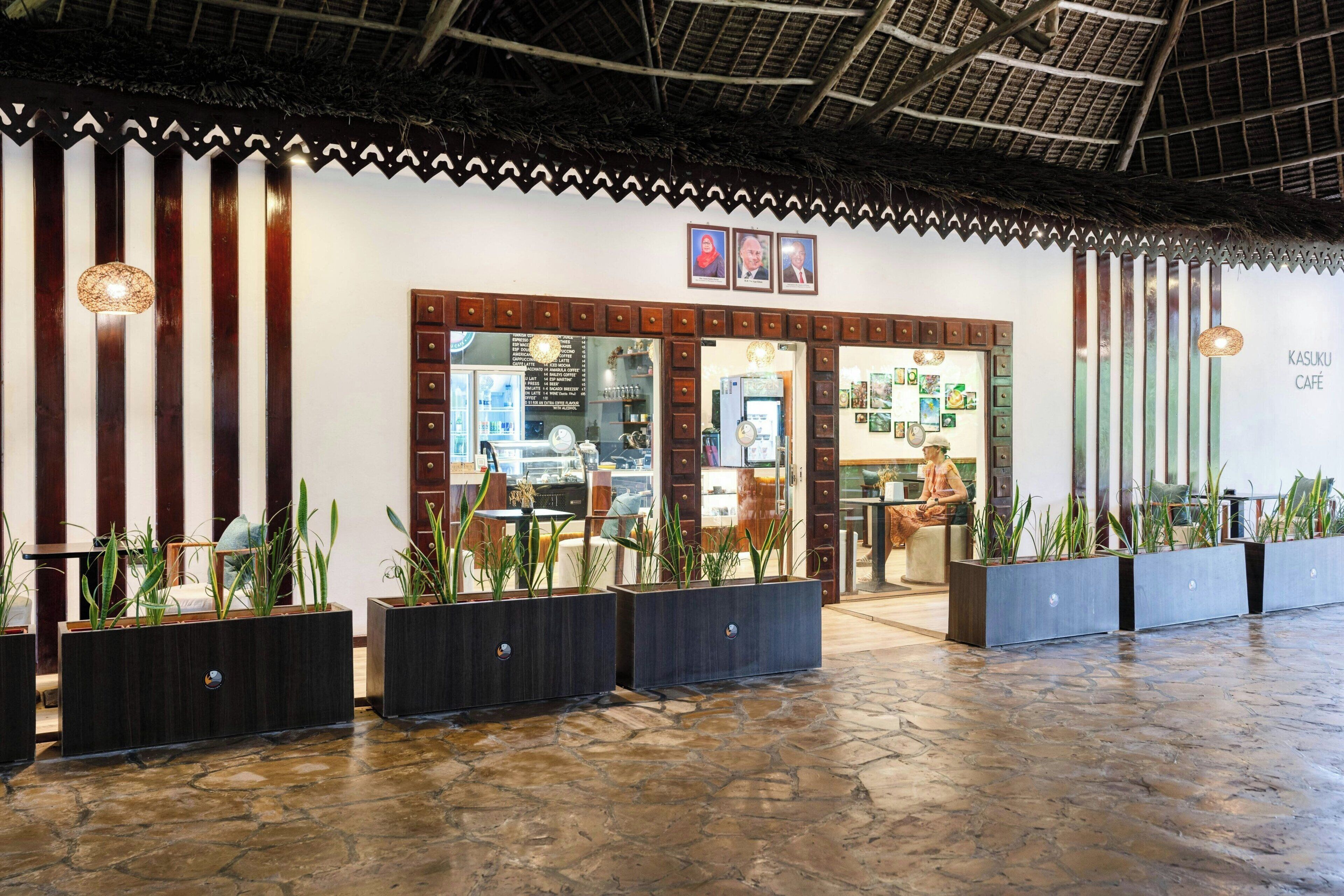 A café with a rustic interior, featuring wooden accents and potted plants.