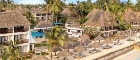 A resort with multiple overwater bungalows, a pool, and a beach area with umbrellas.