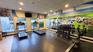 A gym with treadmills, dumbbells, and exercise equipment.