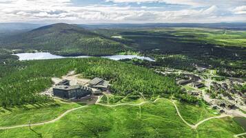 Ett flygbildsbild av ett semesterområde med en stor byggnad, flera vägar och omgivande skogsområden.
