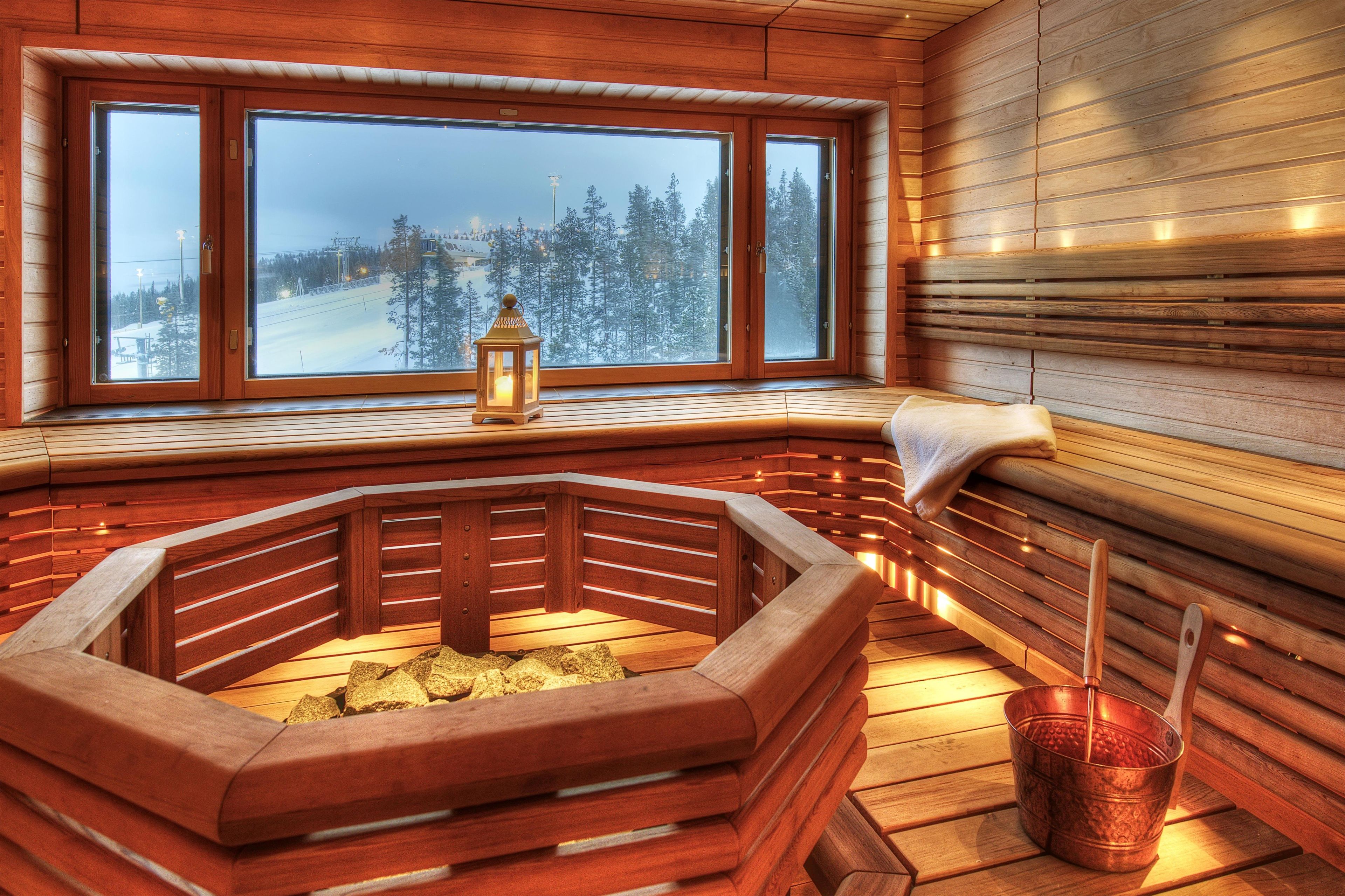 A wooden cabin with a large window overlooking a snowy landscape.