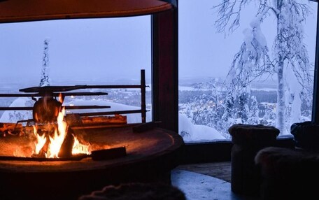A cozy room with a large window overlooking a snowy landscape.