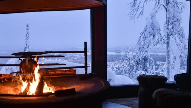 A cozy room with a large window overlooking a snowy landscape. - Hotel Levi Panorama (Kittila)