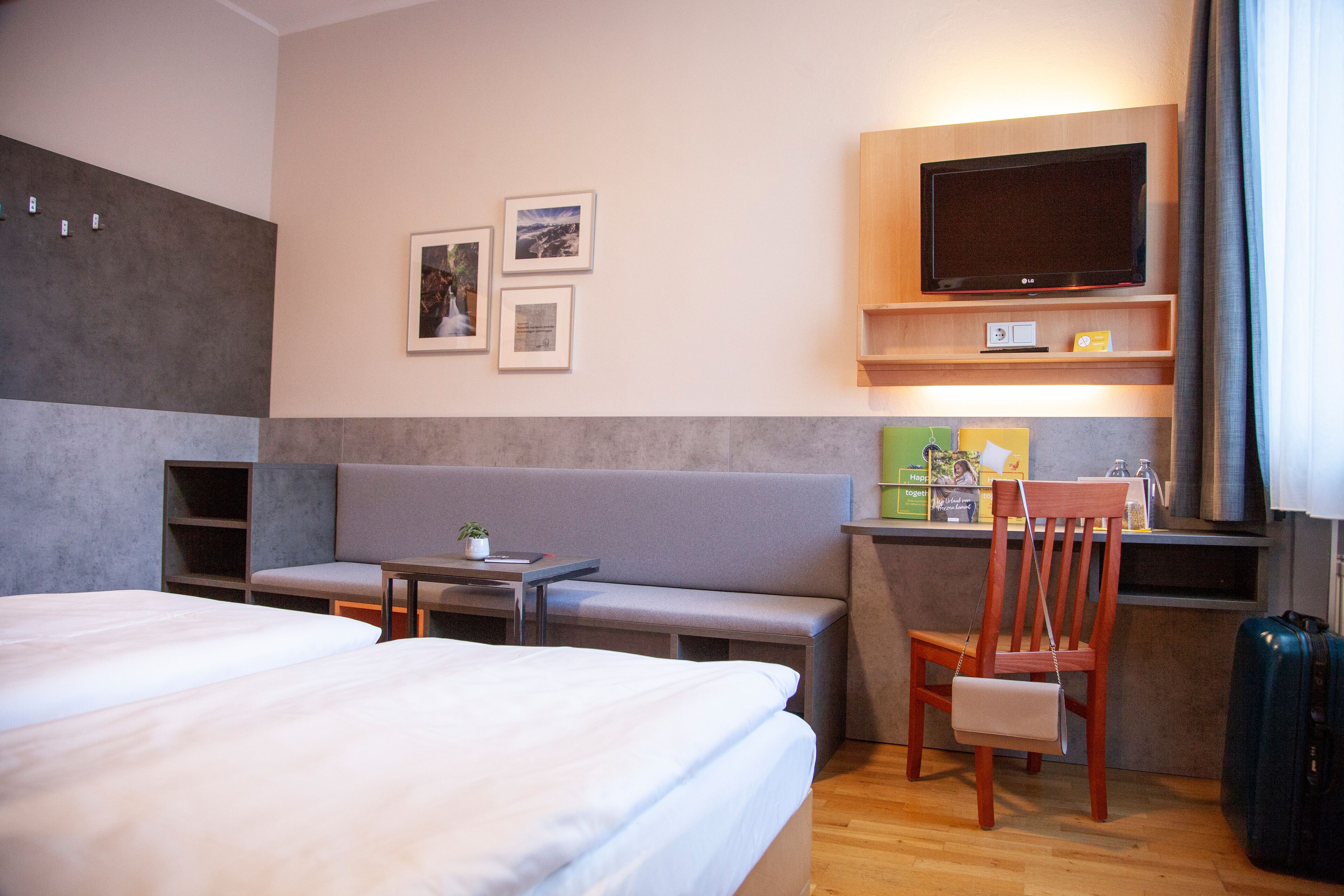 A hotel room with a bed, a sofa, a TV, and a desk.