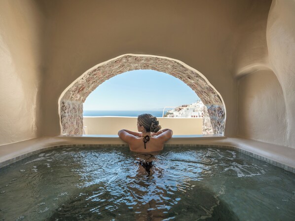 Una persona en una bañera con vista a un pueblo costero.